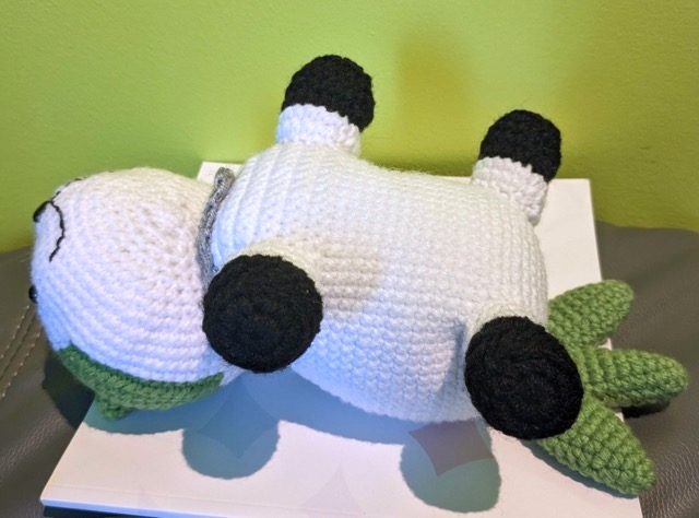 Completed Sommie lying contentedly on its back, tail laid flat and legs splayed out to the sides.